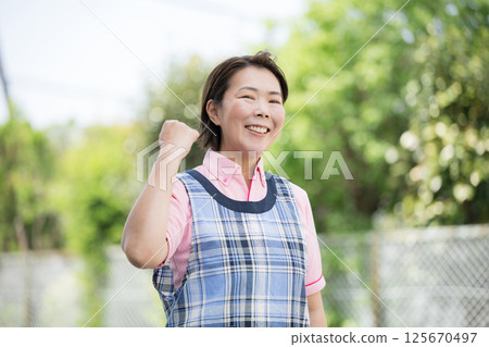 一位資深護理人員或幼兒園老師微笑著抬頭看著鏡頭的圖片 一位資深護理人員或幼兒園老師微笑著抬頭看著鏡頭的圖片 125670497