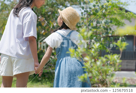 Sisters holding hands in the park 125670518