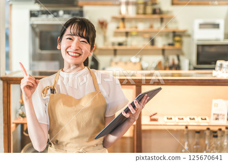 餐廳工作人員(兼職員工、女服務員)在平板電腦上查看訂單 餐廳工作人員(兼職員工、女服務員)在平板電腦上查看訂單 125670641