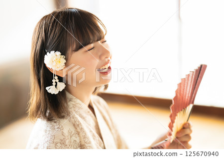 一位身穿浴衣的年輕女子感覺很熱 125670940