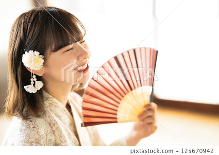 一位身穿浴衣的年輕女子感覺很熱 125670942