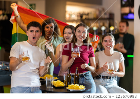 Group of fans in bar with LGBT flag 125670988