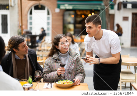 Couple husband and wife ordering from boyfriend waiter in restaurant 125671044