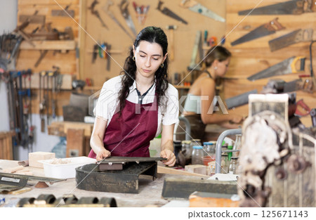 Girl is busy in carpentry workshop 125671143
