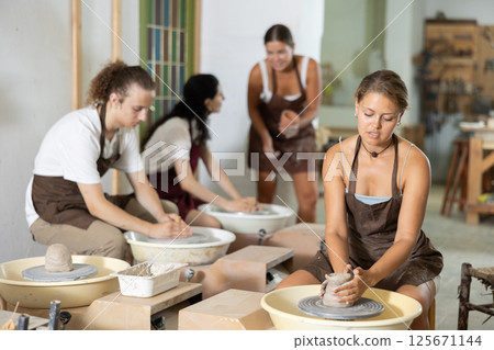 Girl working with pottery wheel 125671144