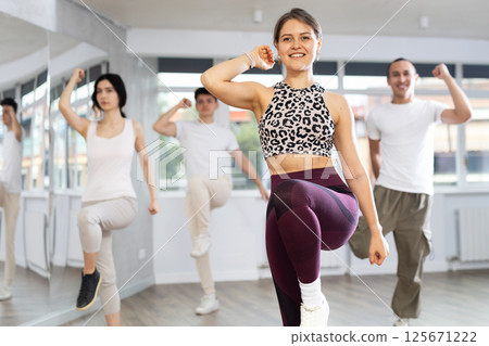 Girl with team of young like-minded people learn to dance modern dances 125671222