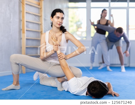 Young woman and guy training self-defense techniques Young woman and guy training self-defense techniques 125671240