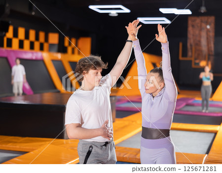 Young guy and adult woman in training for trampolining 125671281