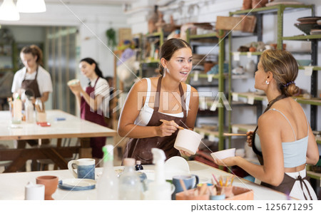 Girl performs polishing of ceramic product 125671295