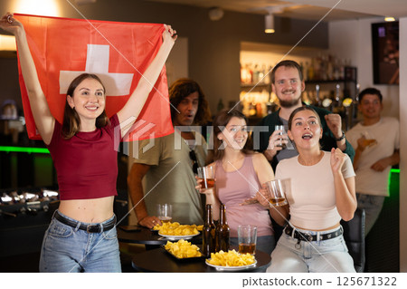 Group of fans in bar with Swiss flag Group of fans in bar with Swiss flag 125671322
