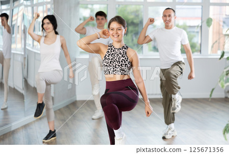 Smiling girl enjoying vigorous dance at group class 125671356