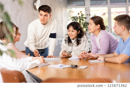 Young male teacher giving lecture to group of students Young male teacher giving lecture to group of students 125671362