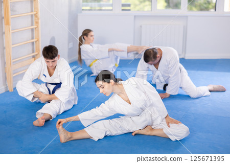 Group of people doing stretching in studio Group of people doing stretching in studio 125671395