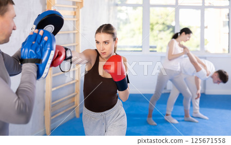 Young woman training in boxing fight in studio 125671558