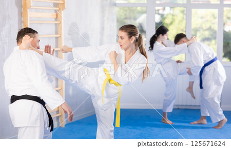 Adult man and young woman training karate techniques Adult man and young woman training karate techniques 125671624