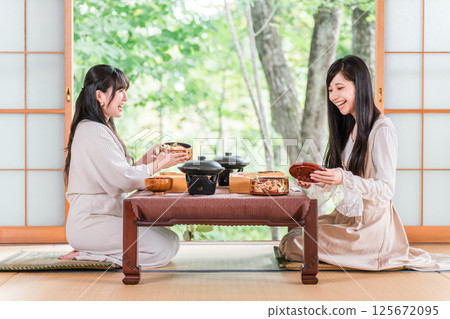 A woman enjoying kaiseki cuisine at a ryokan (room service, kaiseki cuisine, set meal, luxury) 125672095