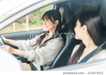 A woman driving a car and her female friend in the passenger seat (driver, drive) 125673031