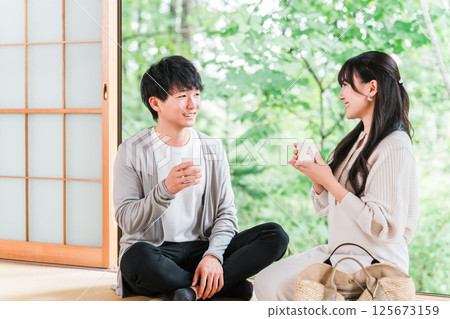 A couple staying at a hot spring inn and Japanese-style room on a domestic trip and looking at the garden view 125673159