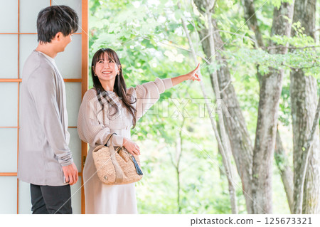 A couple staying at a hot spring inn and Japanese-style room on a domestic trip and looking at the garden view 125673321
