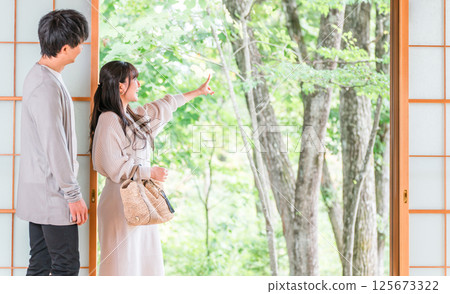 國內旅行入住溫泉旅館或日式房間，欣賞庭園景觀的情侶 125673322