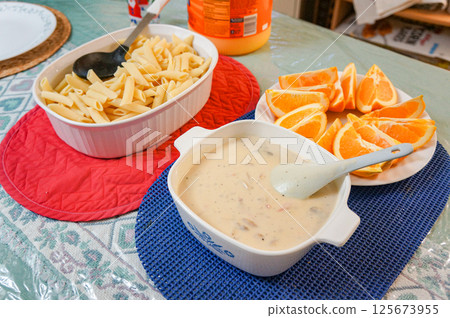 A dinner of clam chowder and macaroni, and an orange snack, prepared by my Canadian host family. 125673955