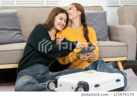 Wellness and togetherness: Women cuddling while reviewing travel details 125674179