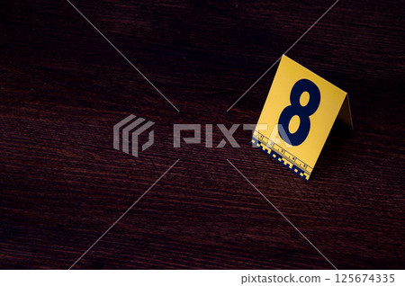 Yellow crime scene evidence marker number 8 on the floor in the room. High quality photo 125674335