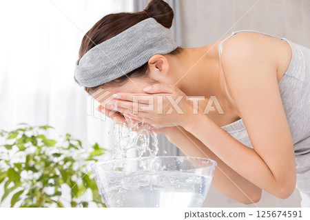 Young Asian woman is washing her face. 125674591