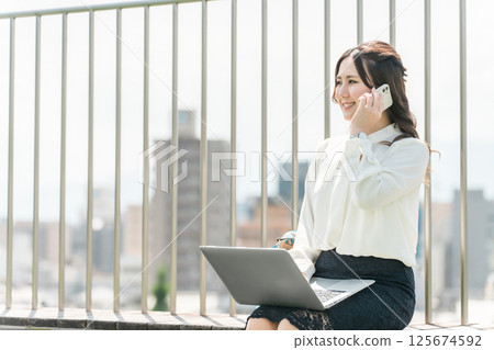 Businesswoman talking on her smartphone on the rooftop (meeting, research, busy) Businesswoman talking on her smartphone on the rooftop (meeting, research, busy) 125674592