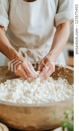 Person preparing fresh homemade cheese in a wooden bowl with hands, emphasizing natural ingredients and traditional techniques, AI Generative 125675403