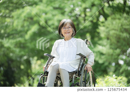 Elderly person in wheelchair looking at camera Elderly person in wheelchair looking at camera 125675434