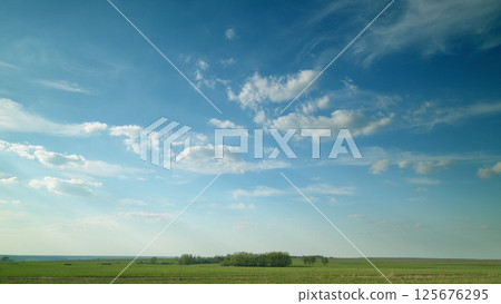 A Serene Sky Spanning Over Lush Green Fields, Casting a Bright and Calming Atmosphere A Serene Sky Spanning Over Lush Green Fields, Casting a Bright and Calming Atmosphere 125676295