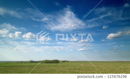 A Beautiful Scenic Landscape Featuring a Vast Sky and Lush Green Fields, Perfect for Exploration 125676296