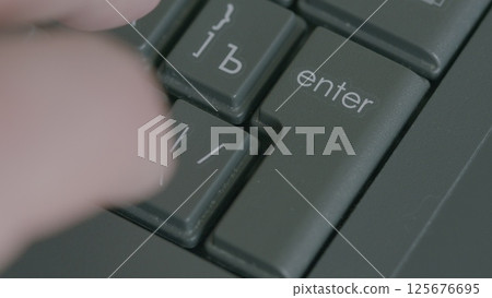 A closeup view of a Keyboards Enter Key being pressed down by a finger during active use A closeup view of a Keyboards Enter Key being pressed down by a finger during active use 125676695