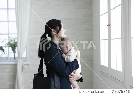 Working mother holding a baby 125676848