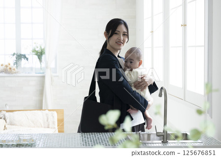Working mother holding a baby 125676851