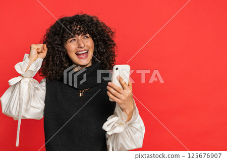 Happy excited winner woman use smartphone celebrating success winning play game good lottery news 125676907