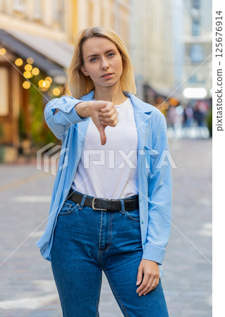 Woman shows thumbs down sign dislike expressing discontent disapproval dissatisfied bad work mistake Woman shows thumbs down sign dislike expressing discontent disapproval dissatisfied bad work mistake 125676914