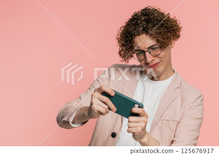 Happy man playing racing drive simulator shooter video games on smartphone celebrate victory win 125676917