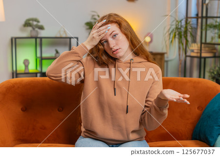 Upset woman making disrespect gesture, disappointed in fail results bad news on sofa couch at home Upset woman making disrespect gesture, disappointed in fail results bad news on sofa couch at home 125677037