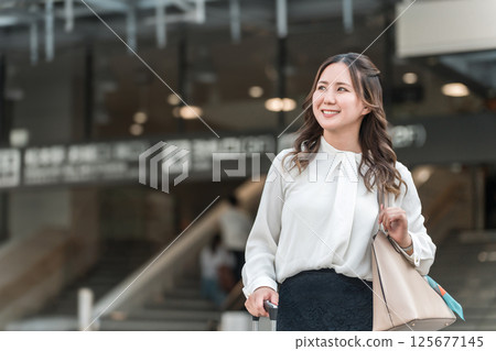 出差或帶著手提箱在車站旅行回來的女商人 出差或帶著手提箱在車站旅行回來的女商人 125677145