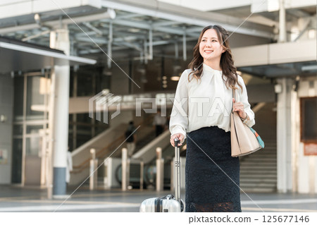 出差或帶著手提箱在車站旅行回來的女商人 出差或帶著手提箱在車站旅行回來的女商人 125677146