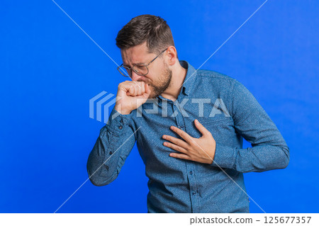Unhealthy ill man coughing with seasonal flu symptoms, sick, allergy, fever or viral infection Unhealthy ill man coughing with seasonal flu symptoms, sick, allergy, fever or viral infection 125677357