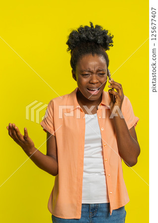 African American woman angry phone conversation, irritated gestures, frustrated expression, tension African American woman angry phone conversation, irritated gestures, frustrated expression, tension 125677407