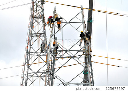 Dismantling an old electricity transmission tower - Scaffolders at work Dismantling an old electricity transmission tower - Scaffolders at work 125677597