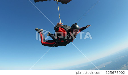 A moment when a skydiver floats in the blue sky 125677902