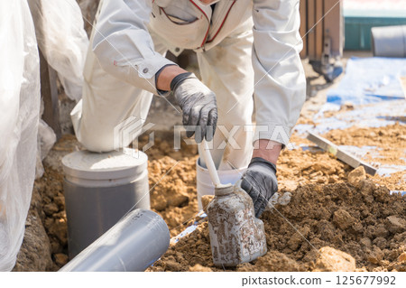 下水管道:建築工人將黏合劑(潤滑劑)塗抹到排水管上 下水管道:建築工人將黏合劑(潤滑劑)塗抹到排水管上 125677992