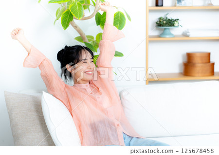 一個年輕女子在沙發上放鬆 125678458