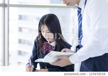 High school students studying at a cram school and their instructor High school students studying at a cram school and their instructor 125678538