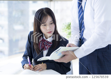 High school students studying at a cram school and their instructor High school students studying at a cram school and their instructor 125678539